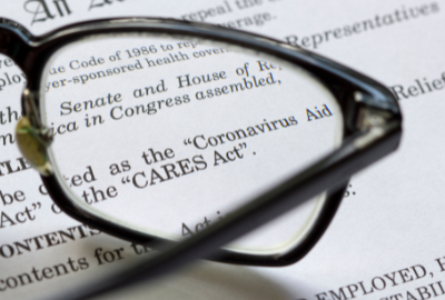 A pair of eyeglasses sitting on a document regarding the CARES act