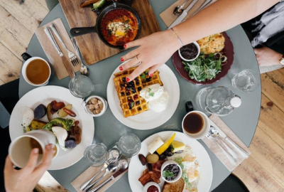 An aerial view of a round table with an array of breakfast foods.