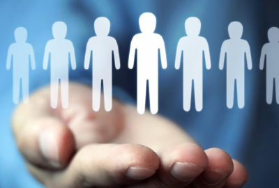 A hand held out palm up with electronic images of people floating above it.